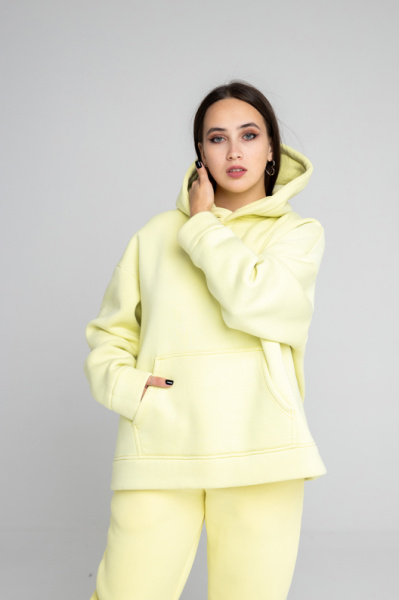 Эта оверсайз толстовка создана в духе современных требований, предлагая стиль и комфорт в одном изделии. Изготовленная из мягкого футера с начесом, она обеспечивает тепло и уют. Пояс и рукава обработаны кашкорсе для дополнительного комфорта и износостойкости. Двухслойный капюшон, с возможностью исполнения со шнурком или без, добавляет универсальности и функциональности. Внутренний слой капюшона выполнен из основной ткани, что подчеркивает внимание к деталям. Нанесите свой логотип, и ваша команда будет выделяться, создавая уникальный и запоминающийся образ.
Толстовка оверсайз объема, рукав втачной со спущенной линией плеча, низ обработан манжетой из кашкорсе, на полочке накладной карман «кенгуру». Горловина имеет втачной капюшон из двух деталей с подкладкой из основной ткани, имеет кулиску со шнуром, вставленным в выметанные петли (может быть без шнурка). Верхний капюшон отстрочен по среднему шву на плоскошовной спецмашине. Низ изделия обработан поясом из кашкорсе. Длина изделия до середины бедра. Декоративные отстрочки на плоскошовной спецмашине по плечевому шву и шву проймы.